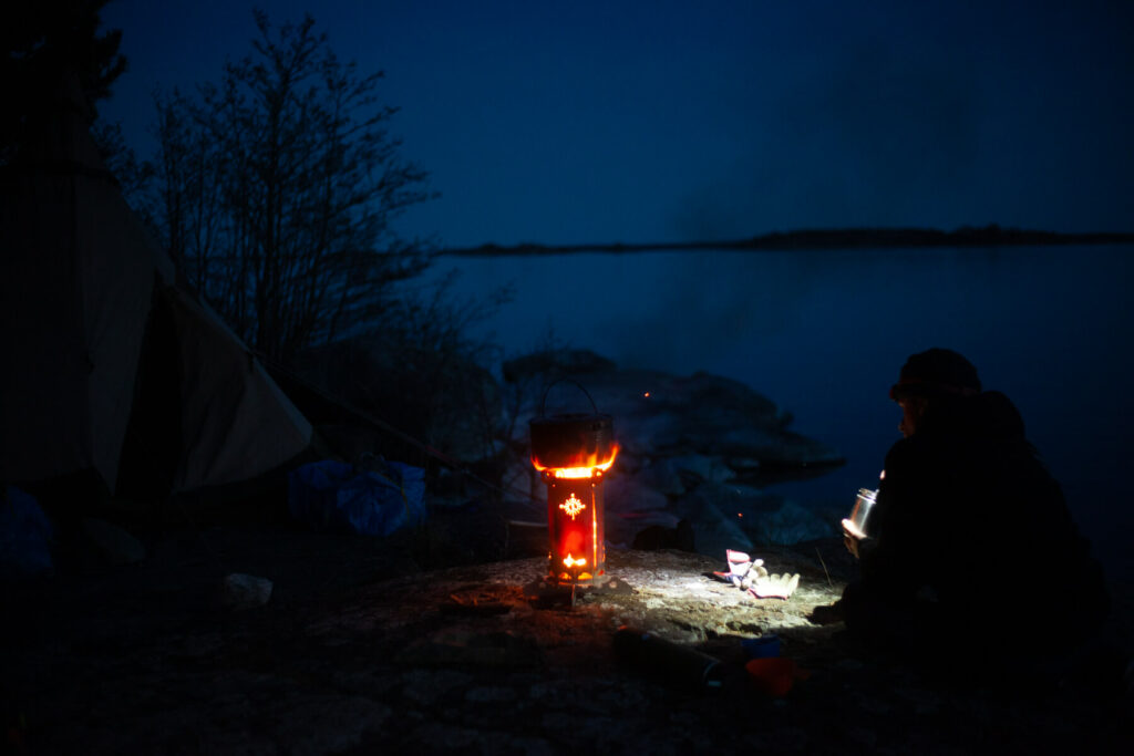 Preparing a meal by the campfire after a day of kayaking