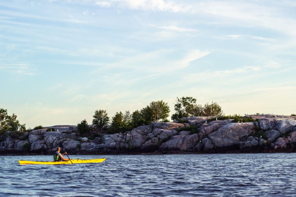 Kayaking along the coastline, marveling at the imposing rock formations rising from the sea