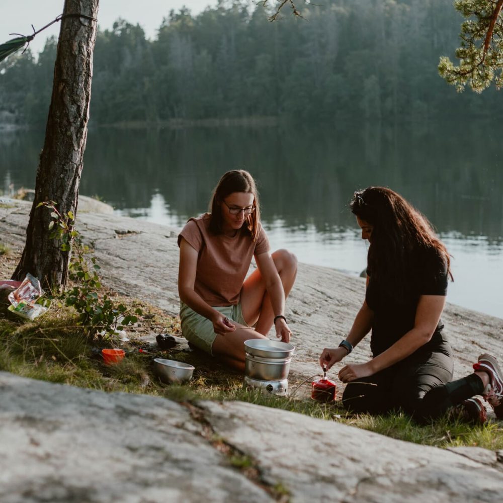 Friends grilling together in the outdoors, enjoying a moment during their adventure.