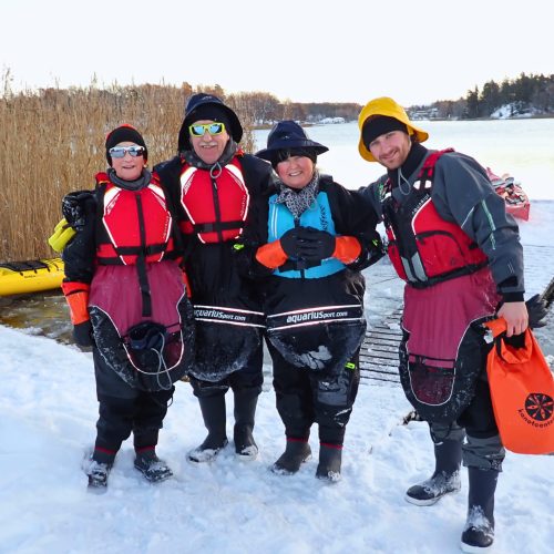 Family kayaking together in a winter landscape