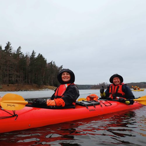 Kayaker paddling through icy waters