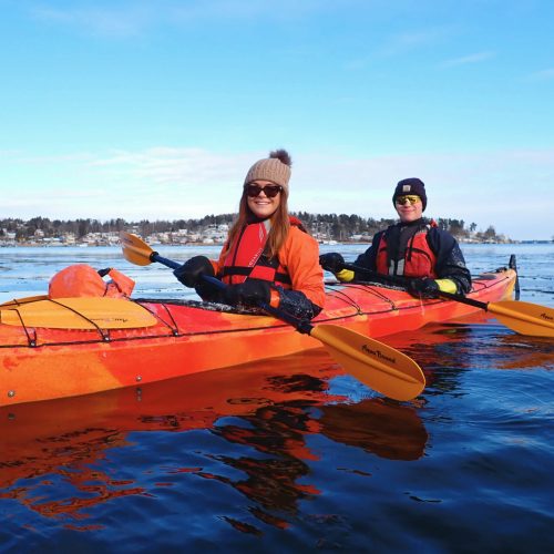Kayaker paddling through icy waters