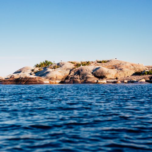 Rocky islands with vibrant blue sea and sky, showcasing the stunning beauty of the archipelago.