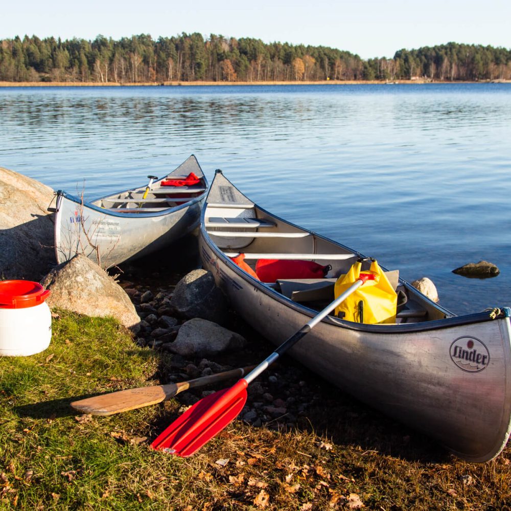 Two canoes parked on a rocky shoreline with blue sea in the background in Bogesund Nature Reserve.