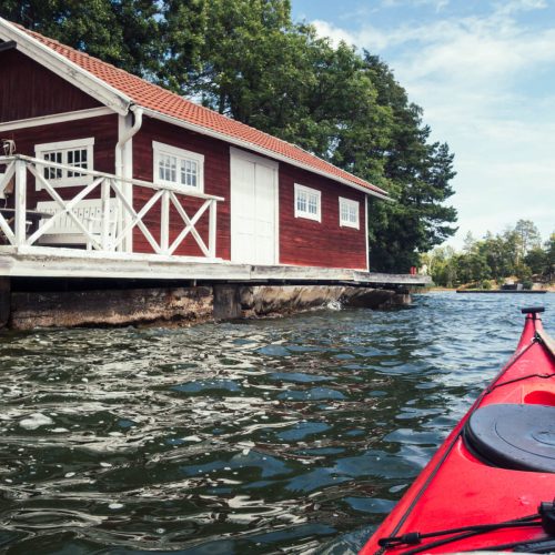 Spotting the iconic red Swedish cottages nestled among the coastal landscape, adding a pop of color to the scenery