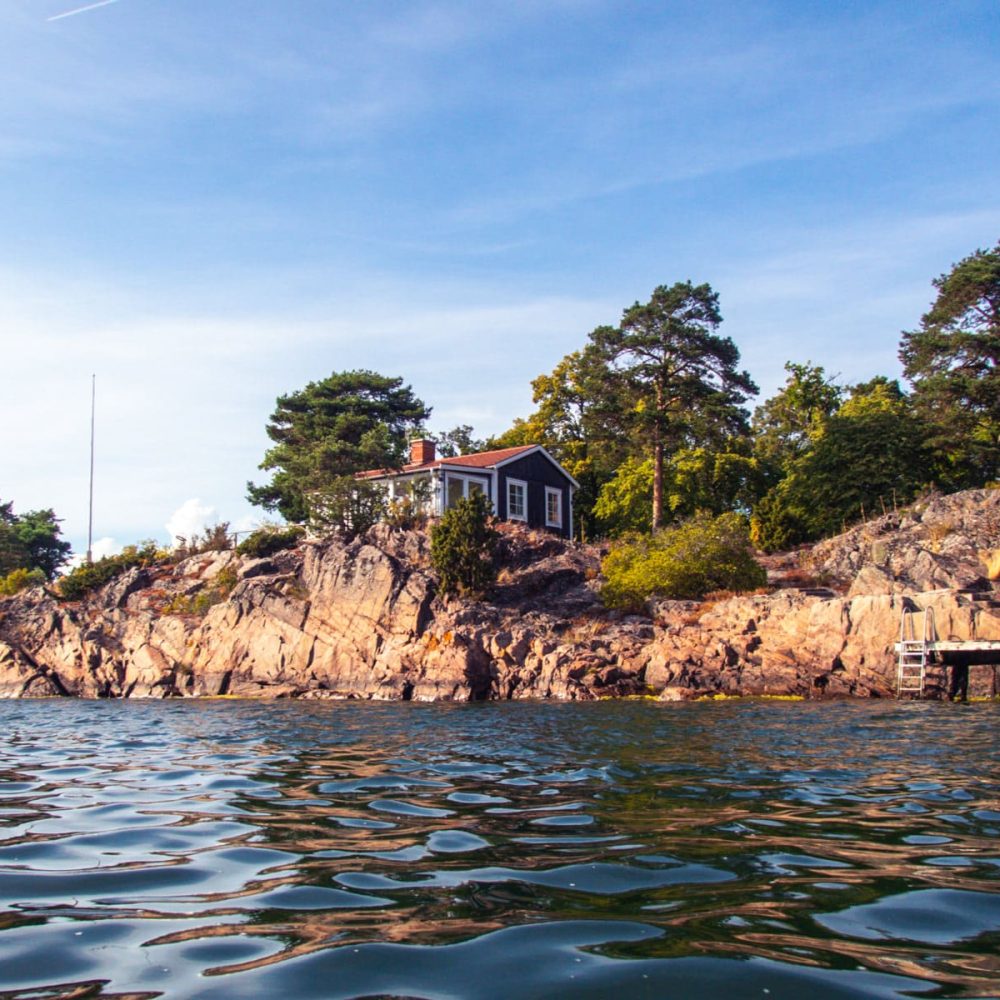 Spotting the iconic red Swedish cottages nestled among the coastal landscape, adding a pop of color to the scenery
