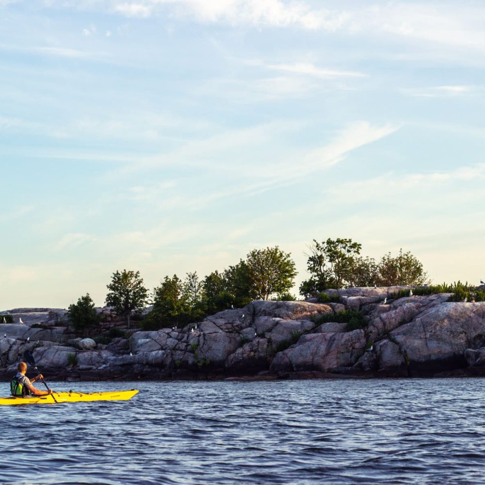 Kayaking along the coastline, marveling at the imposing rock formations rising from the sea