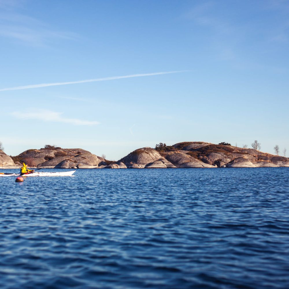 Paddling in the serene beauty of sky, sea, and rocks