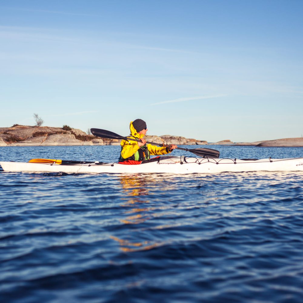 Paddling in the serene beauty of sky, sea, and rocks